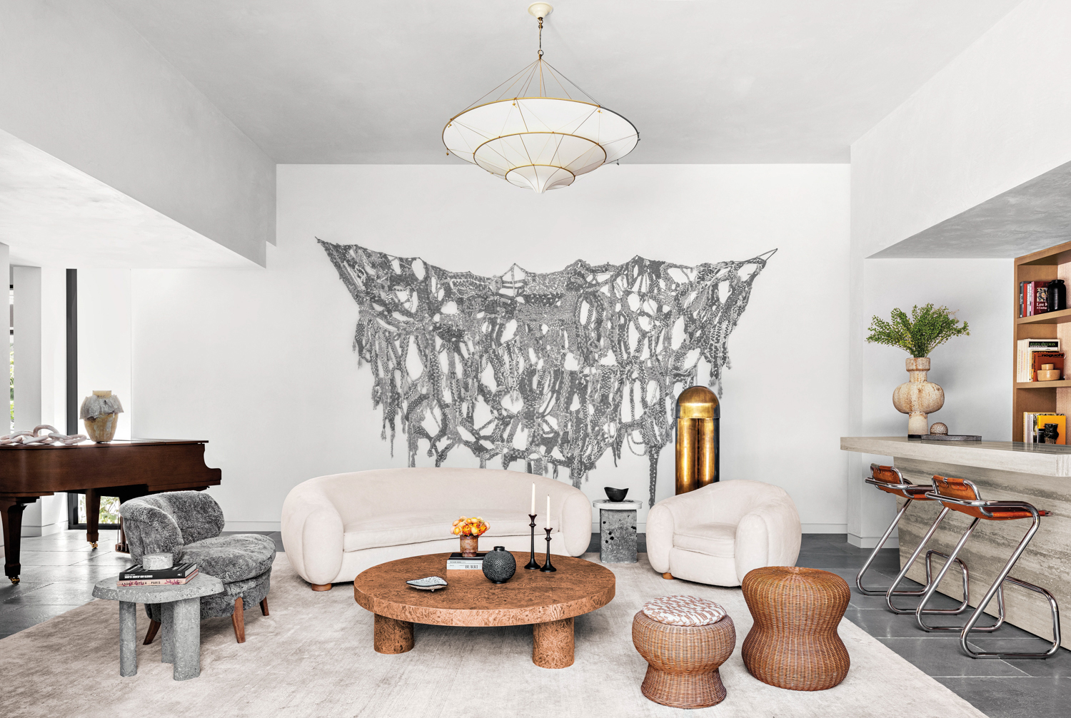 living room with silver artwork, white seating and wooden table in home by Costanza Collarte