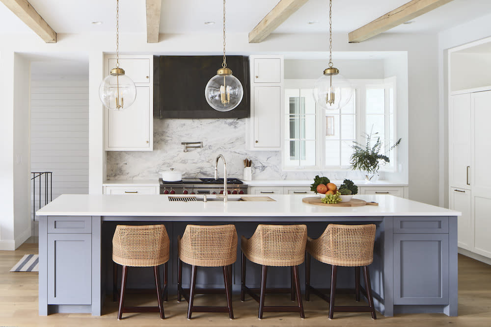 Coastal kitchen design with exposed beams and blue island. 