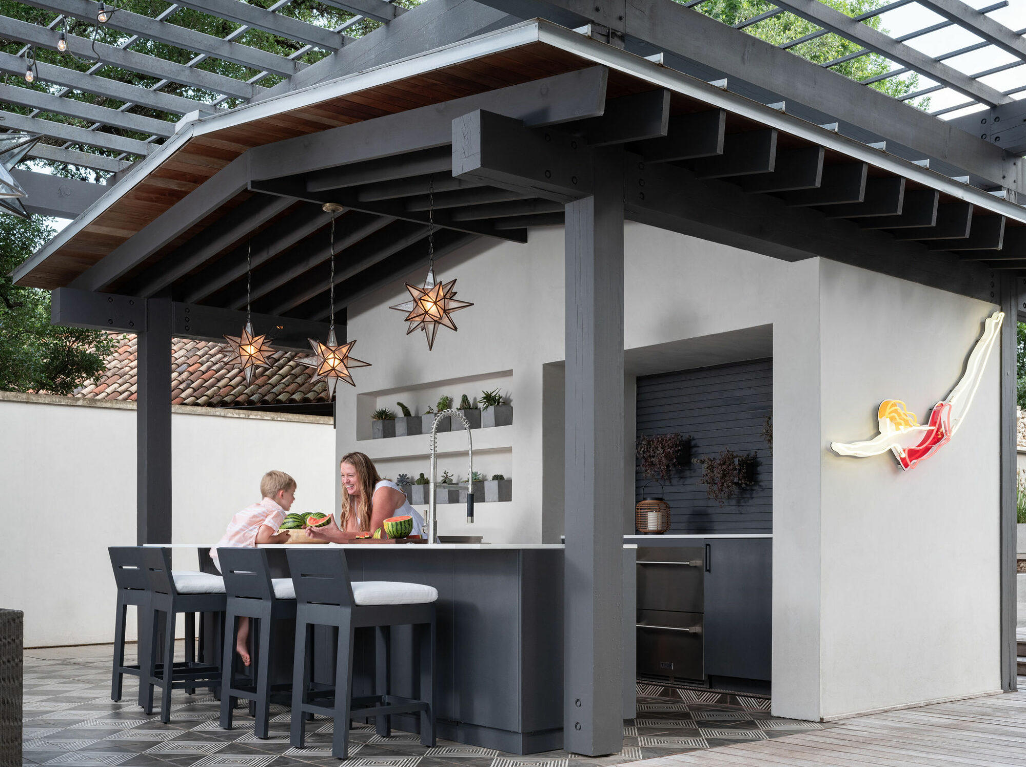 a woman and boy sitting at a table in front of a white house