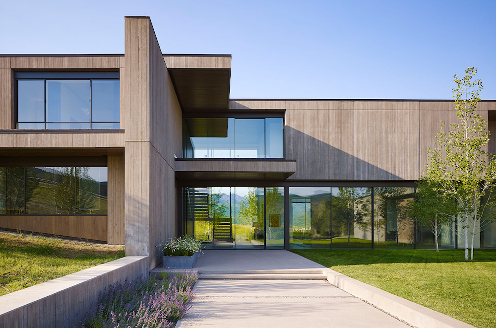 This modern, concrete home has a lot of large glass windows to take in the beautiful views.