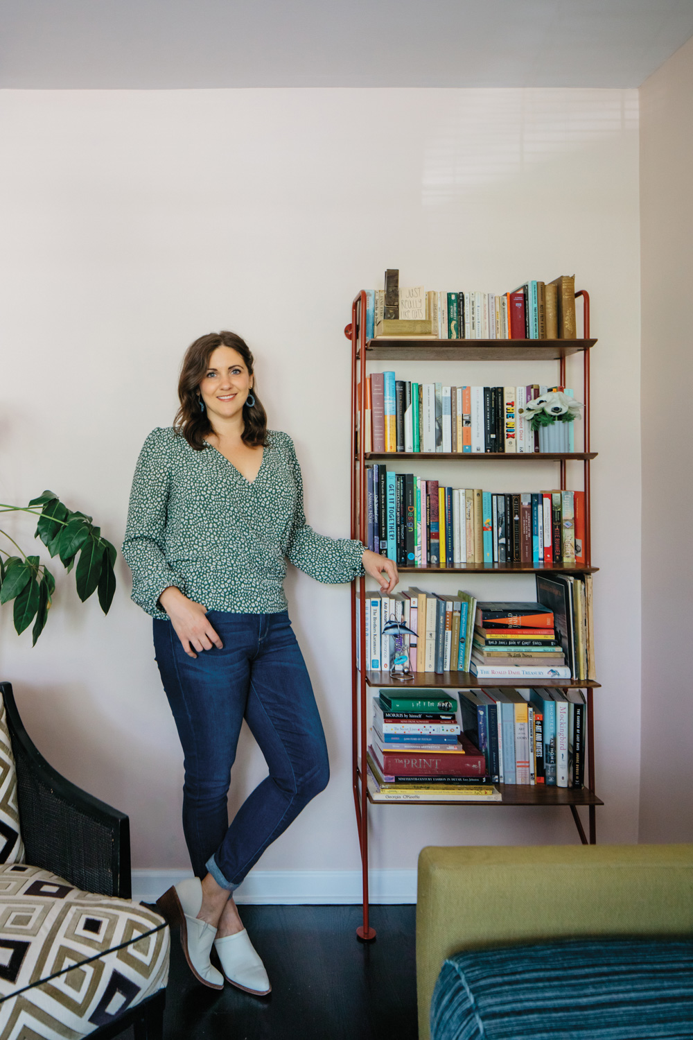 Portrait of designer Sarah Montgomery by a bookshelf.