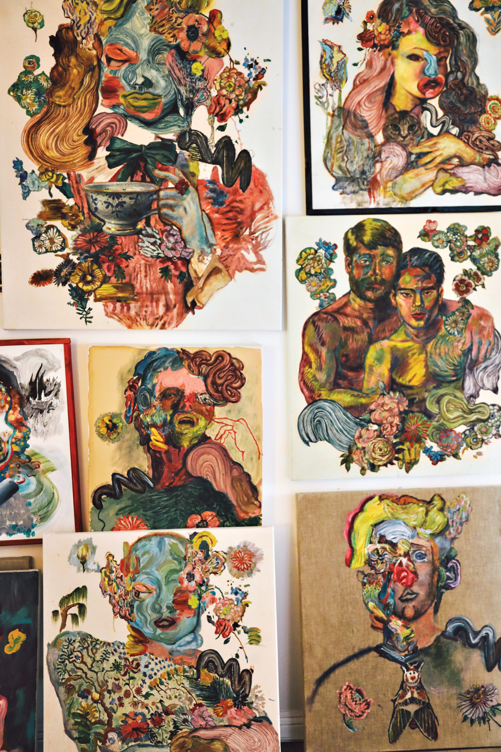 Multiple artworks by Ken Gun Min depicting female figures and two men hugging hanging on a wall.