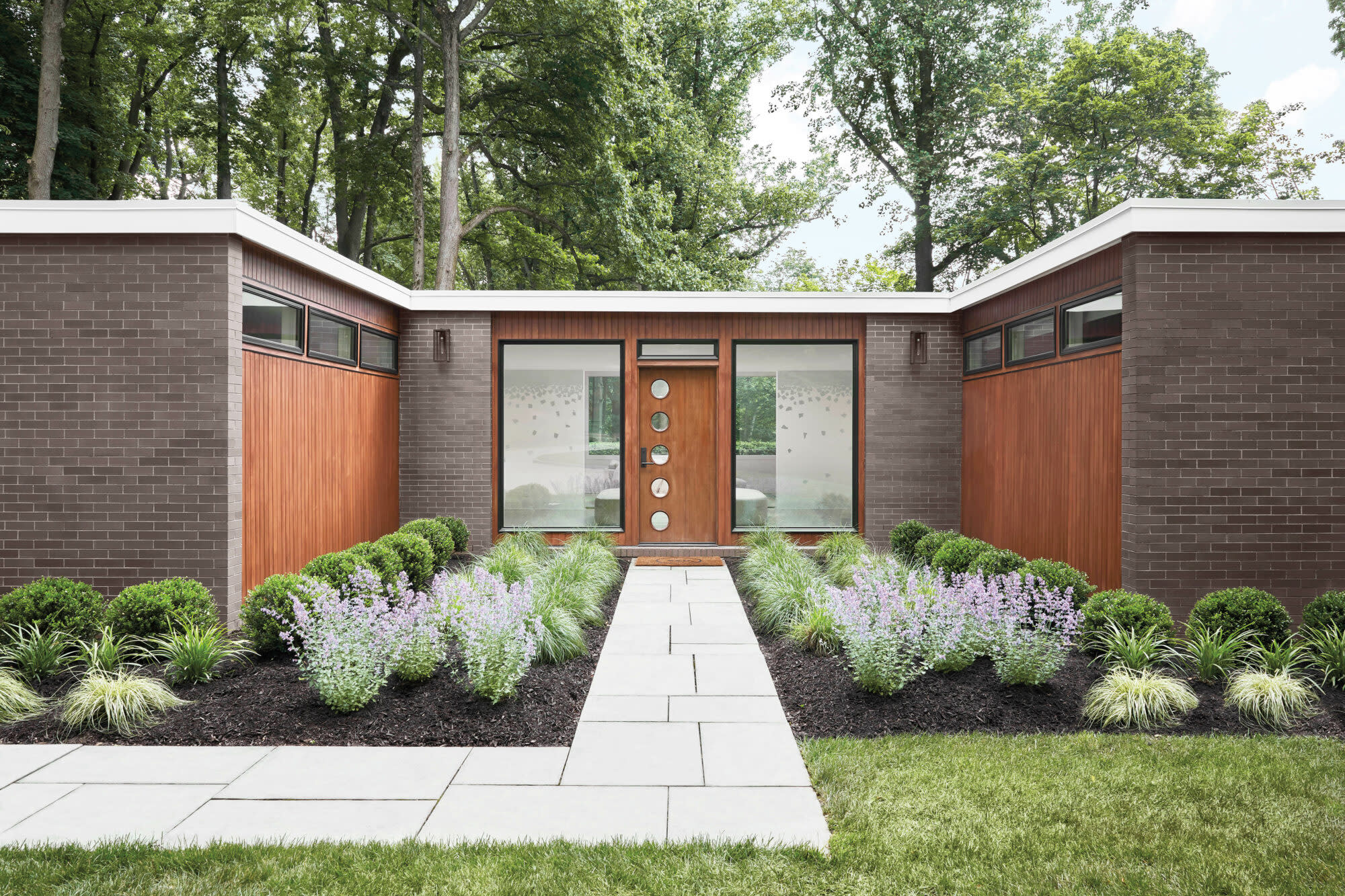 Cara Woodhouse's midcentury home's exterior with wood door and circles