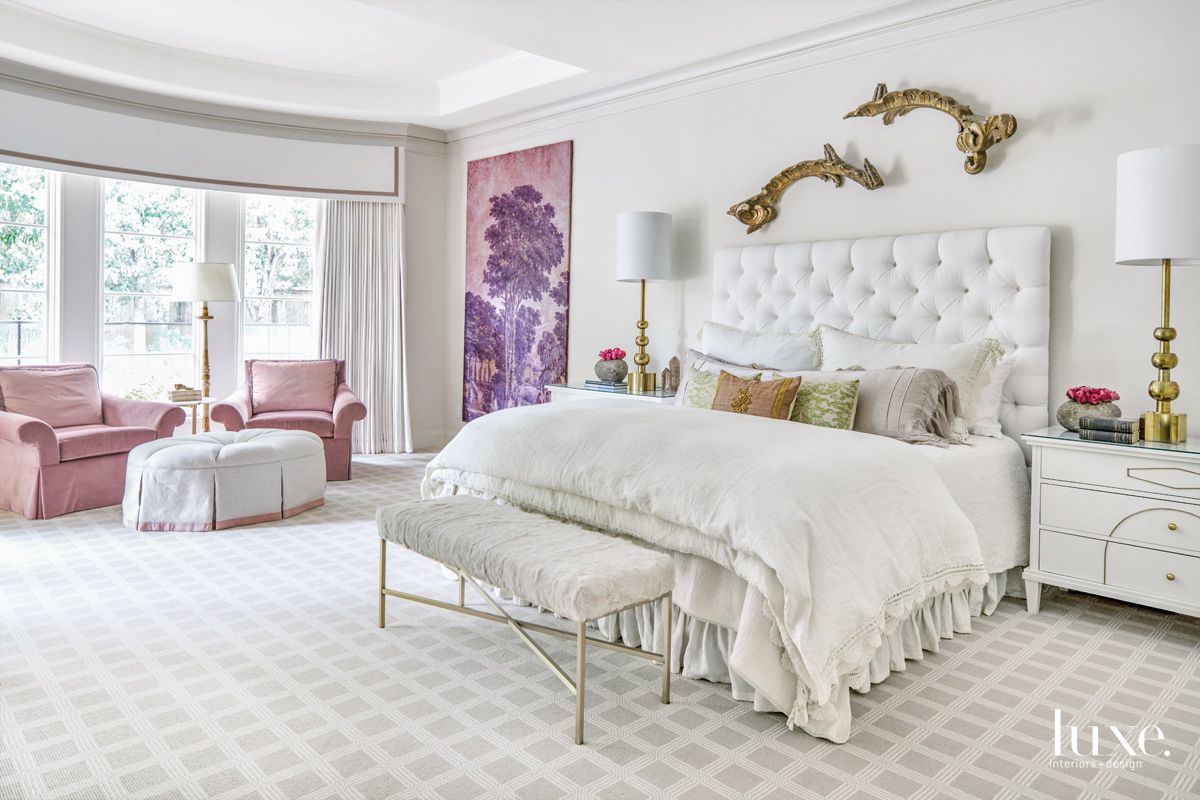 white bedroom with pink and purple painting and pink chair