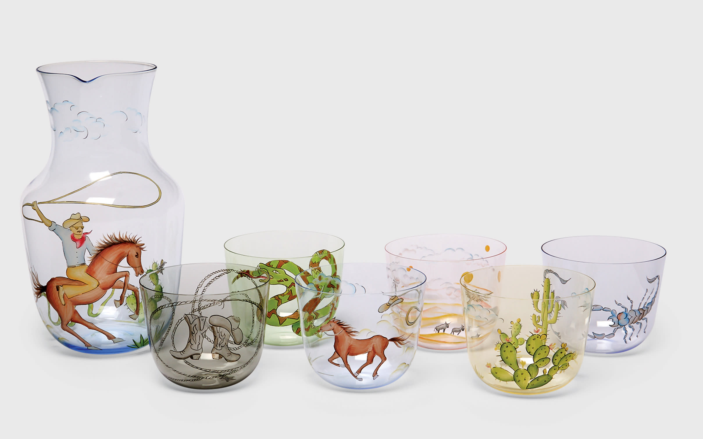 drinking glasses and a carafe with cowboy motifs