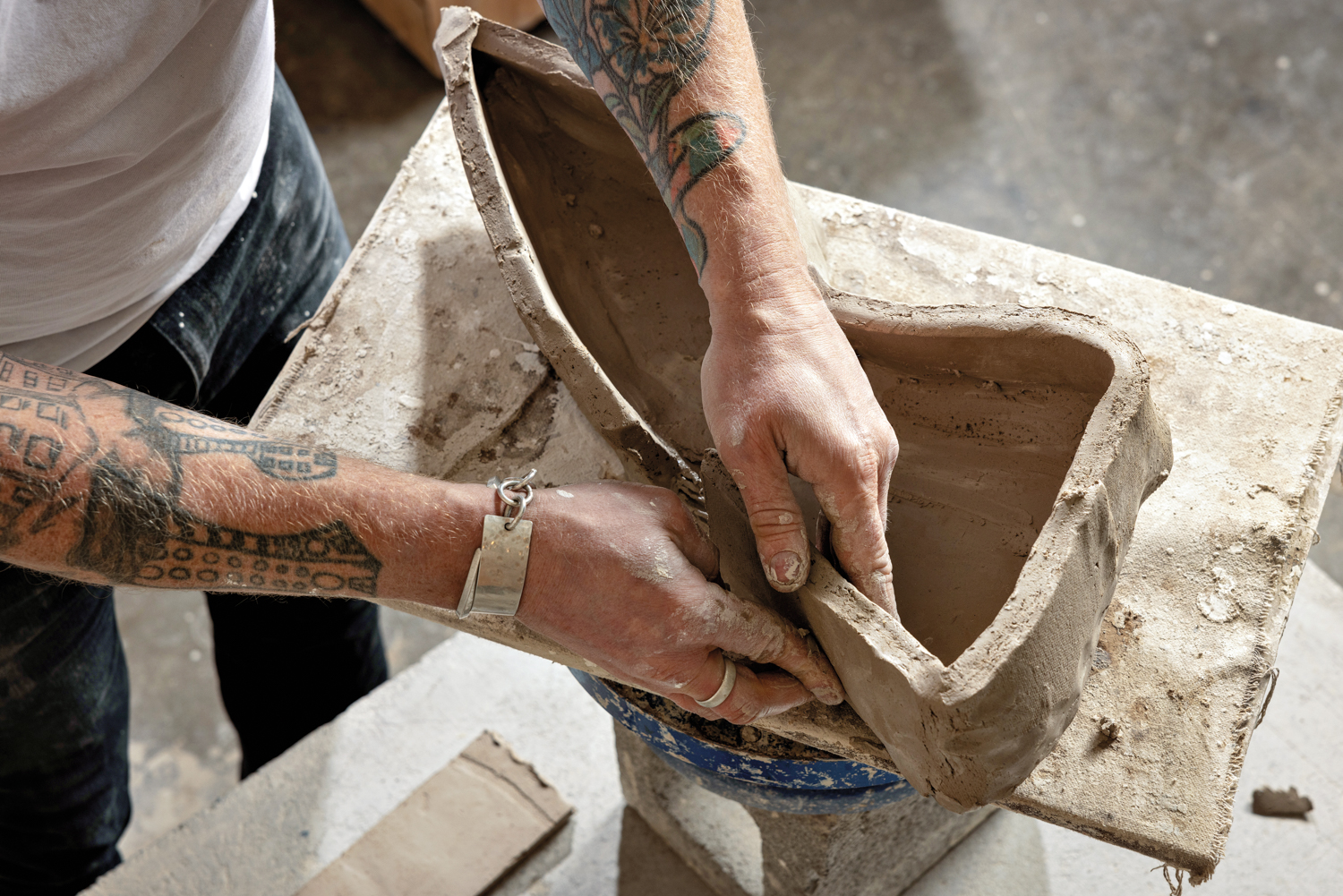 Hands shaping clay.