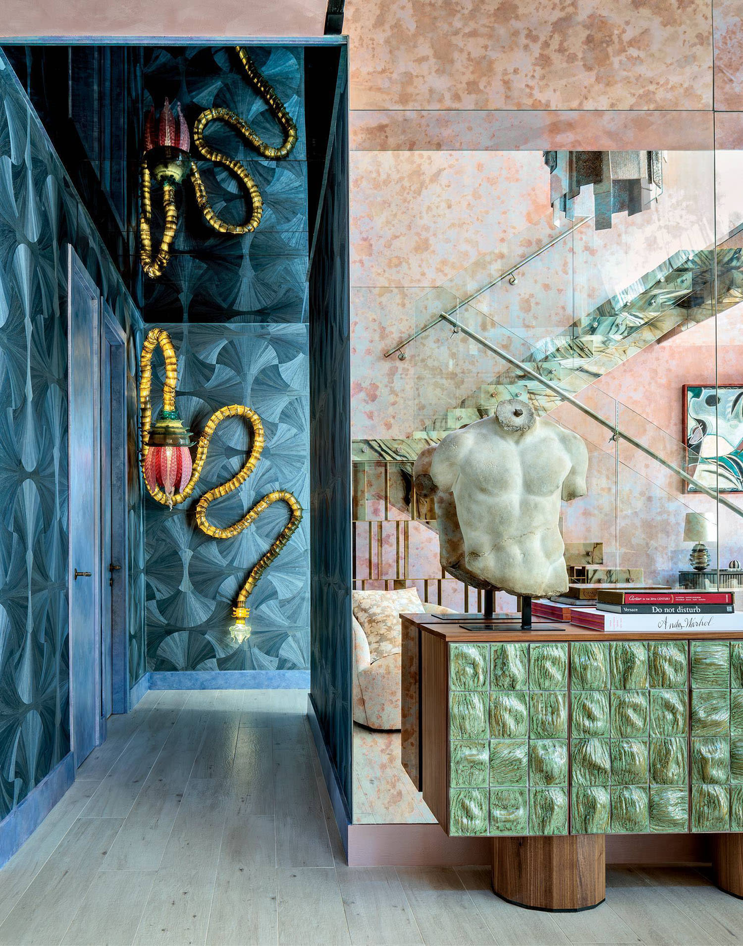 a blue wallcovering backs a Christian Pellizzari lamp in a hallway by the entryway of a Miami home