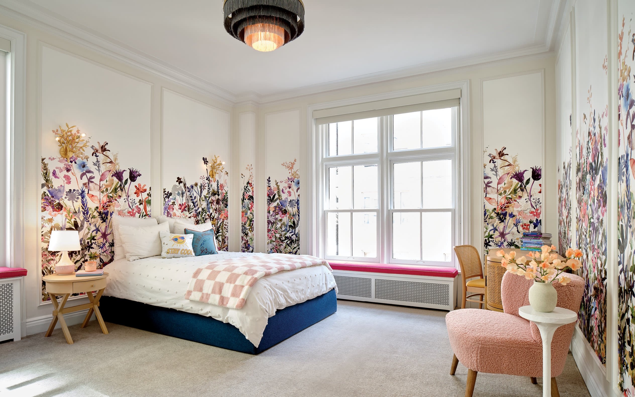 girl's bedroom with floral wallpaper and a blue bed