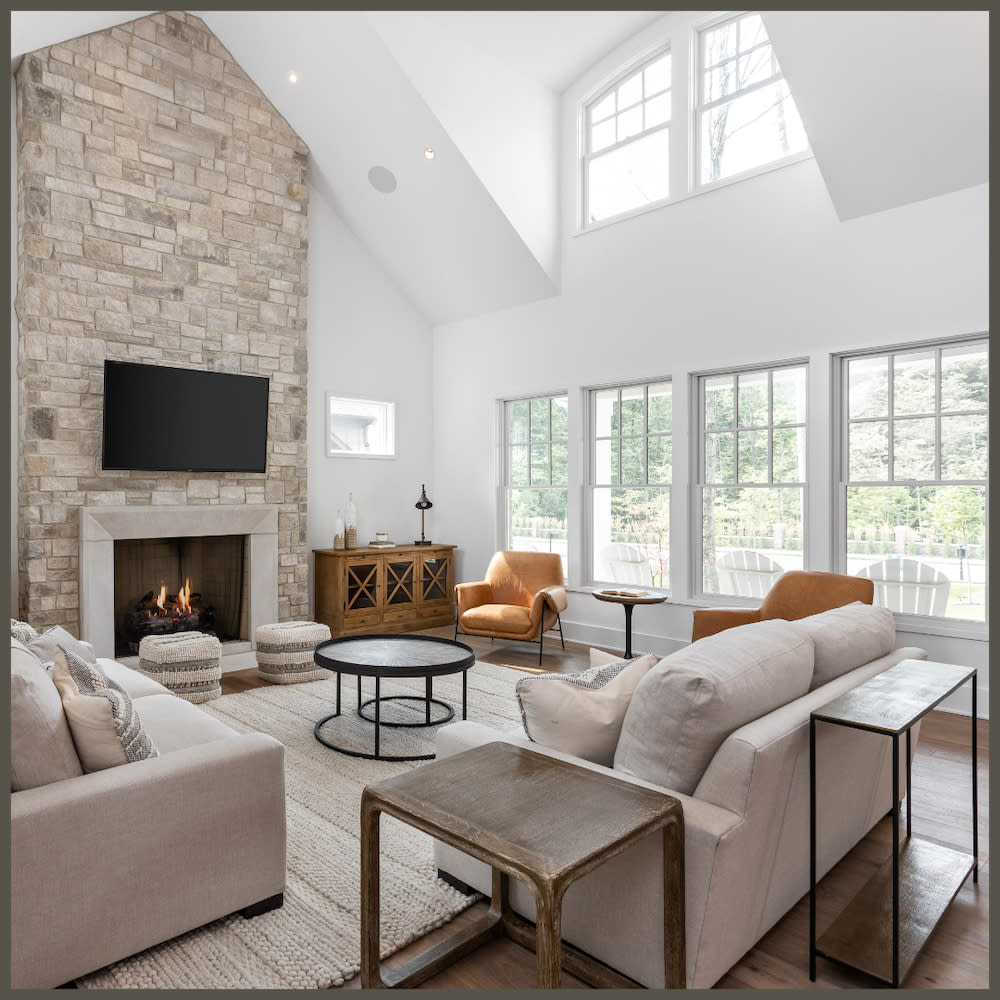 A stylish living room showcasing a stone fireplace alongside a television, perfect for family gatherings and entertainment.