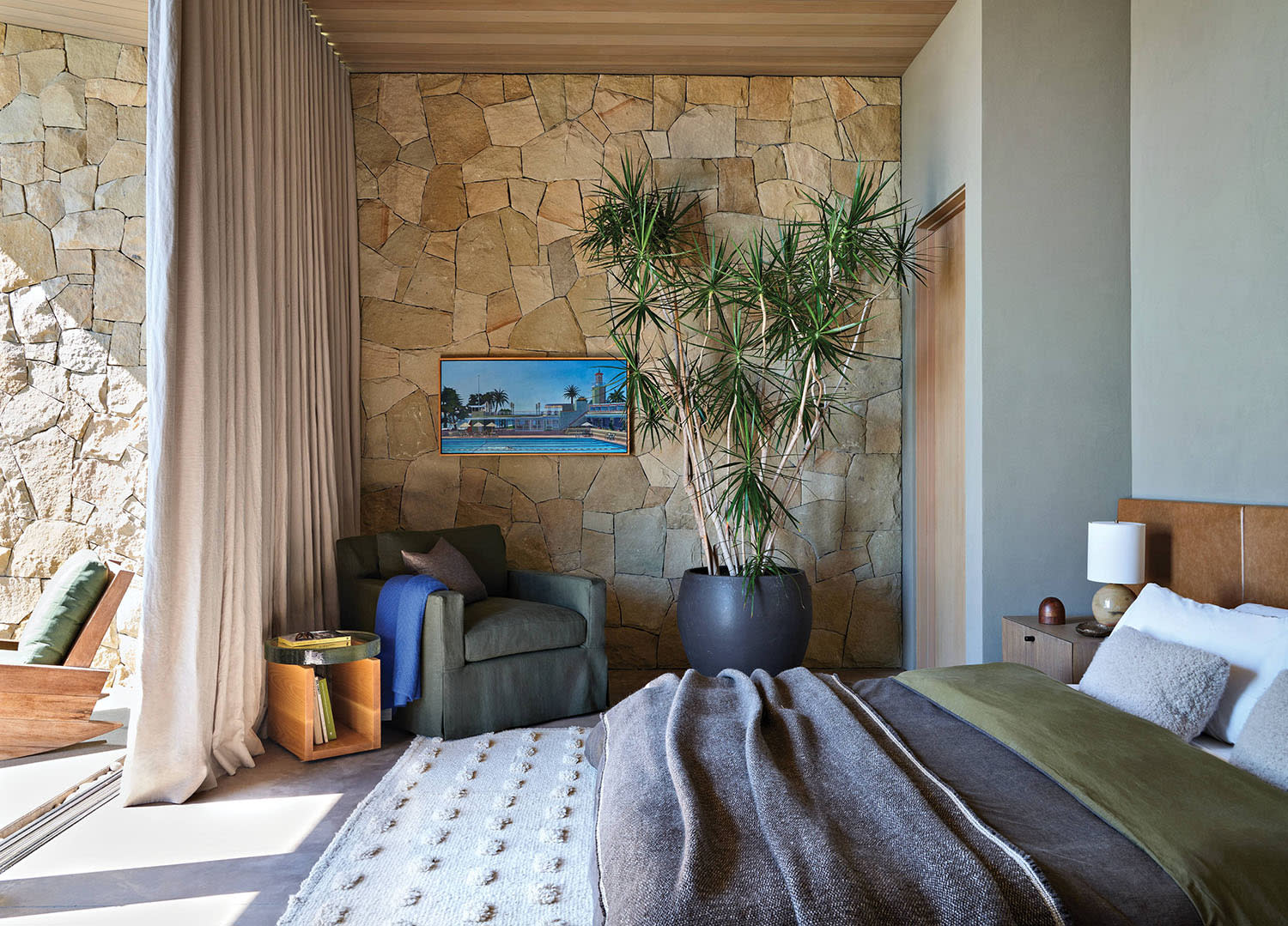 cozy bedroom with a platform bed and stone wall