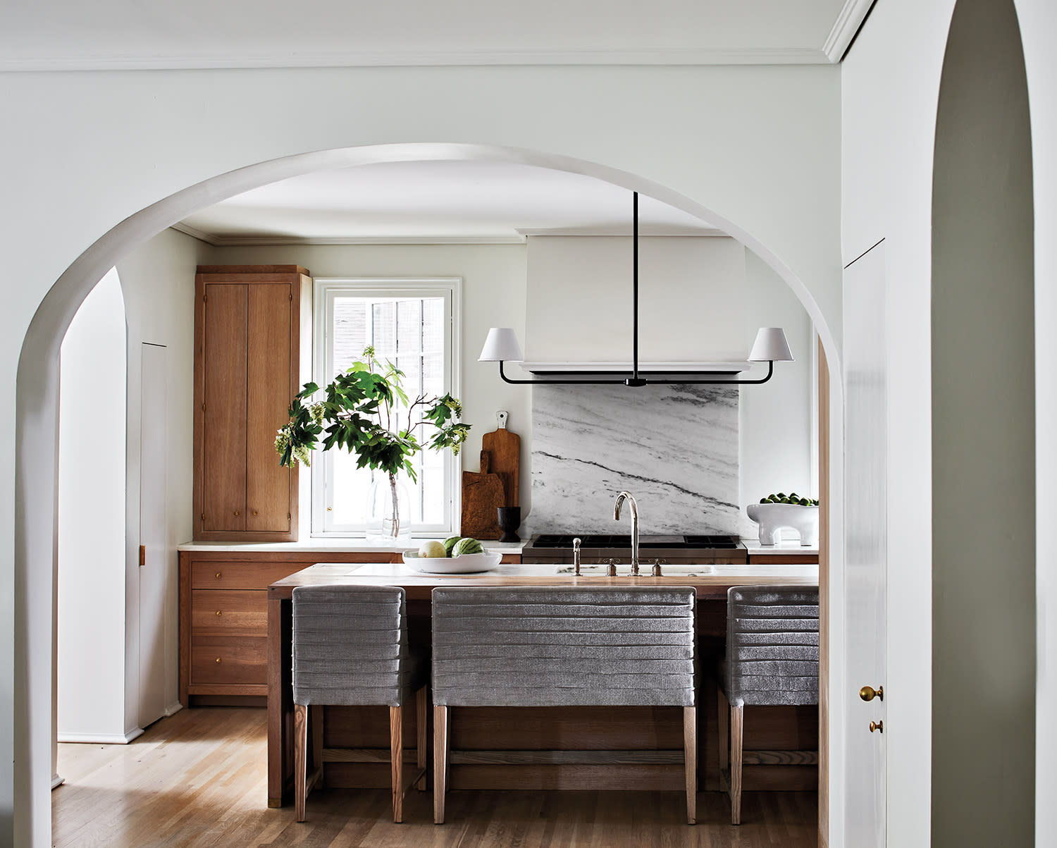 A kitchen featuring an archway that leads into a spacious dining area.
