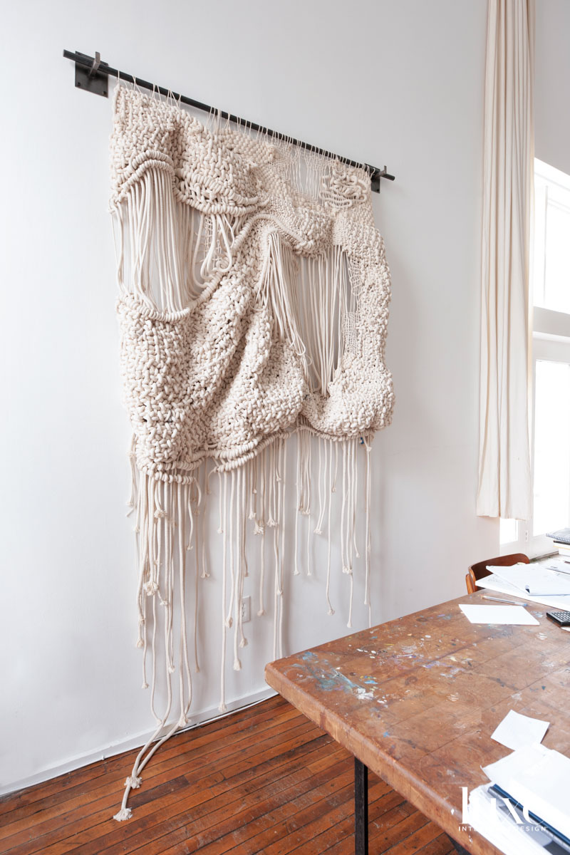 A rope weaving hanging on a white wall.