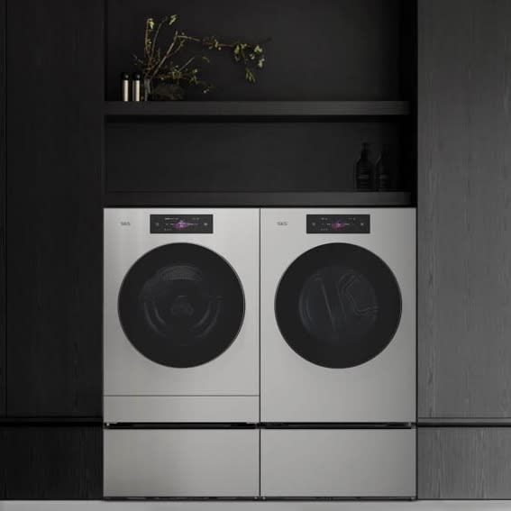 Modern laundry room with sleek black cabinetry and a white washer and dryer