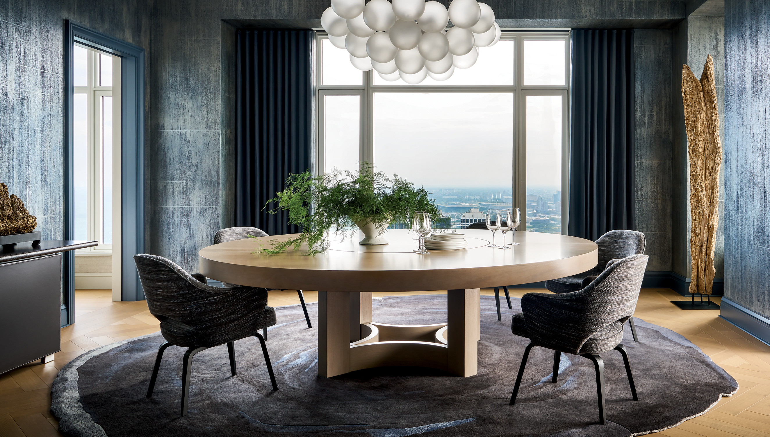 modern dining room with a blue color palette and a light oak round table