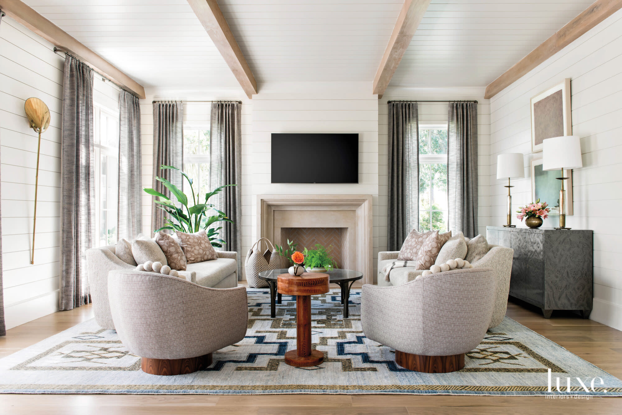 Ivory living room with fireplace and beige armchairs
