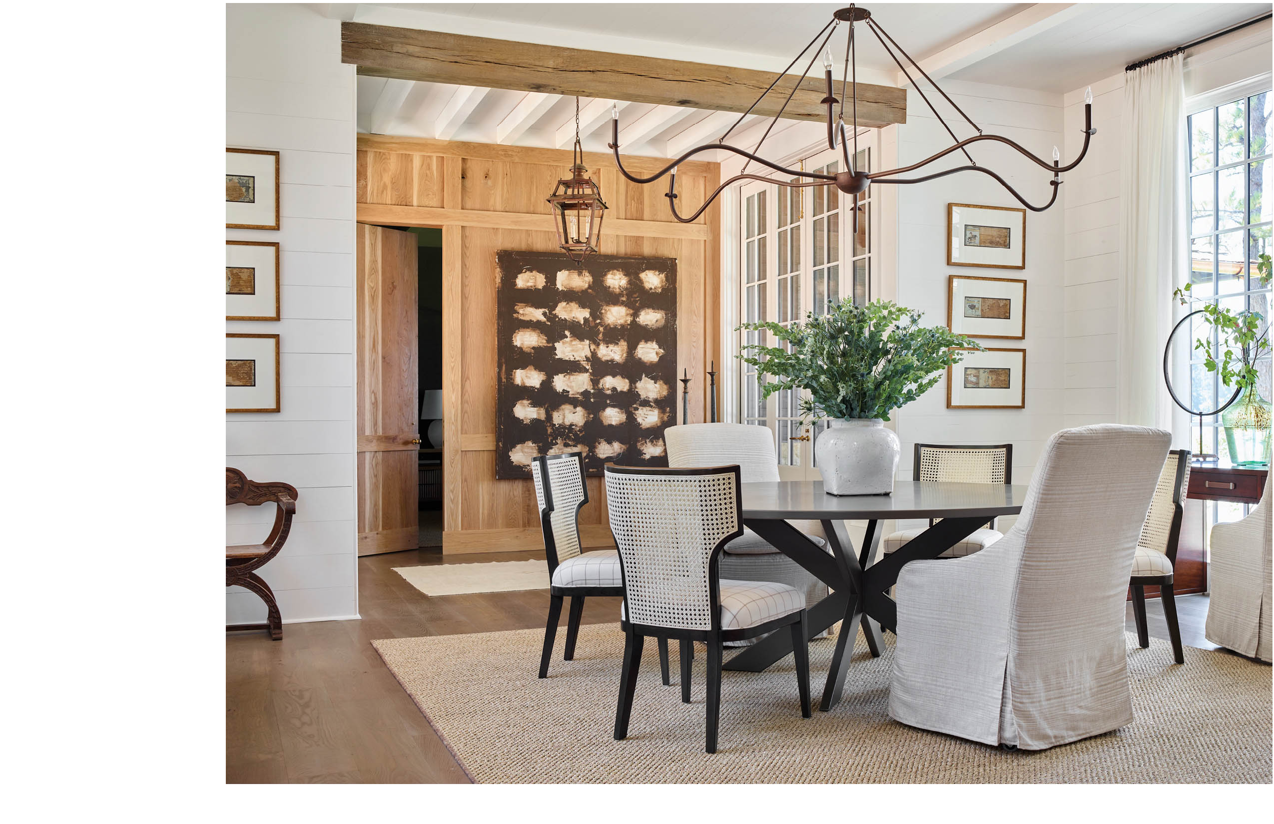 Room with circular dining table, a mix of slipcovered head chairs and side chairs