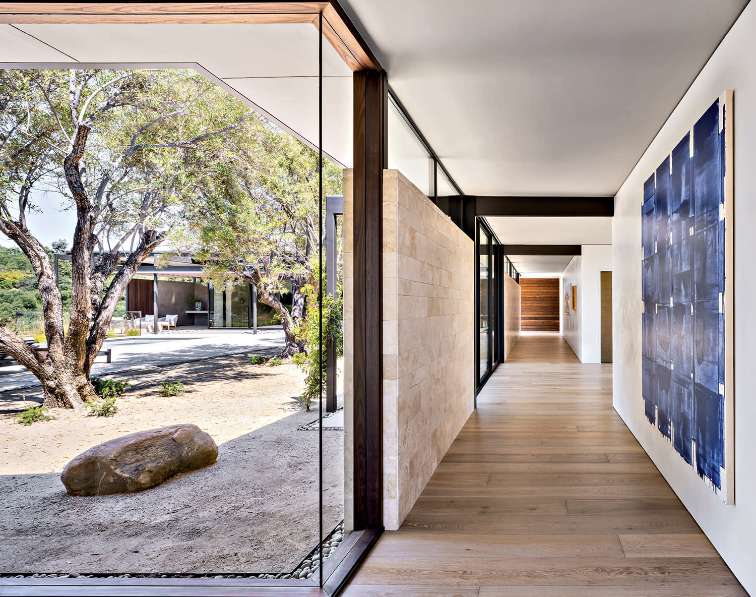 gallery wall of a home with expansive windows and a large-scale blue artwork