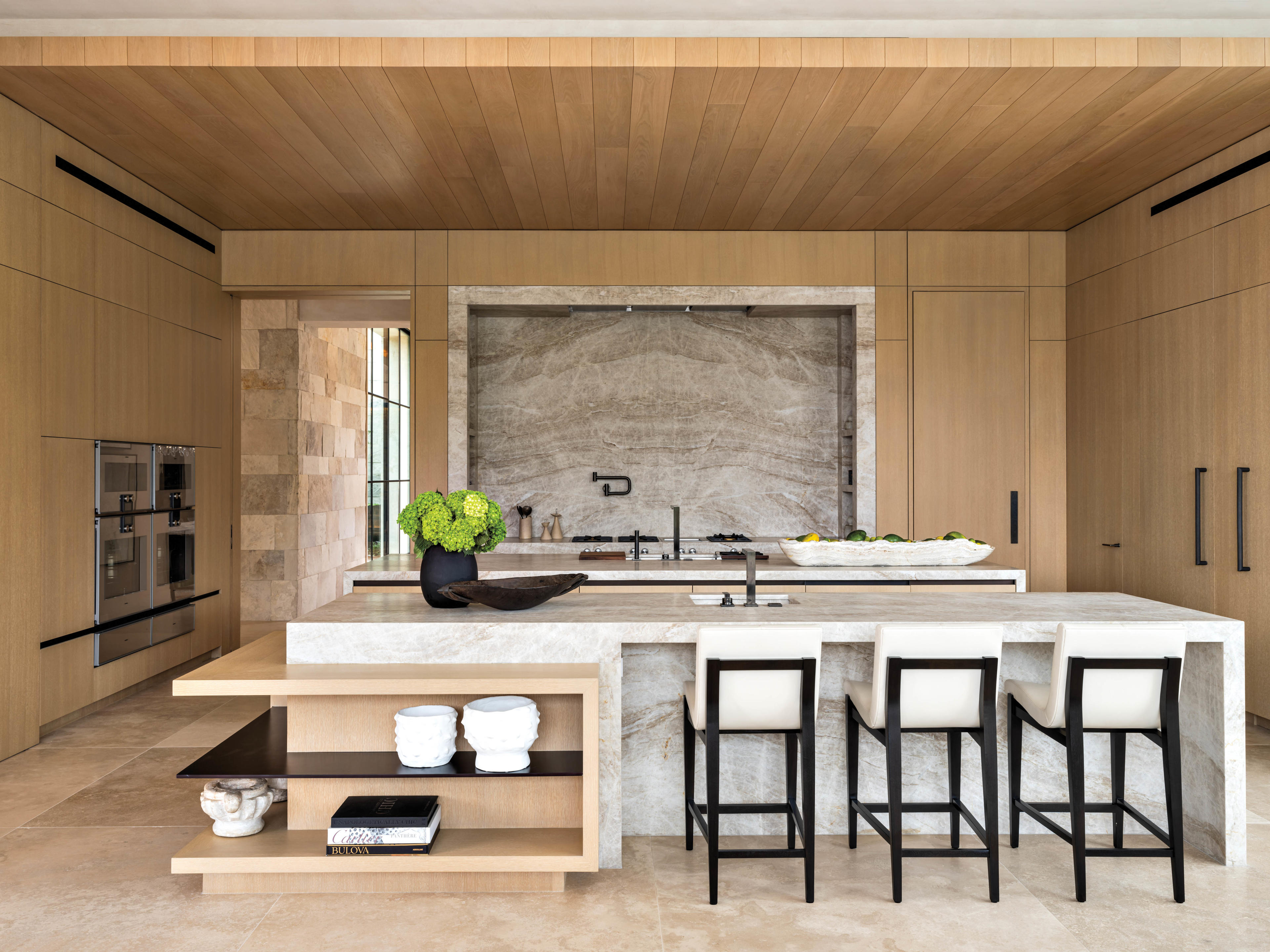 minimalist neutral kitchen with double island and limestone cladding