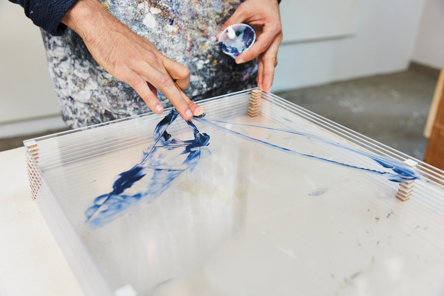 Bronson Shonk applies blue paint to his fingers