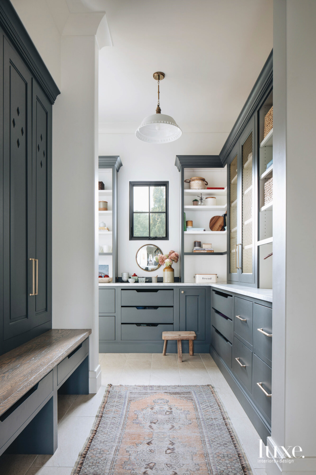 A dark, neutral-toned blue-gray adds a pop of color to the cabinetry in the all-white pantry.