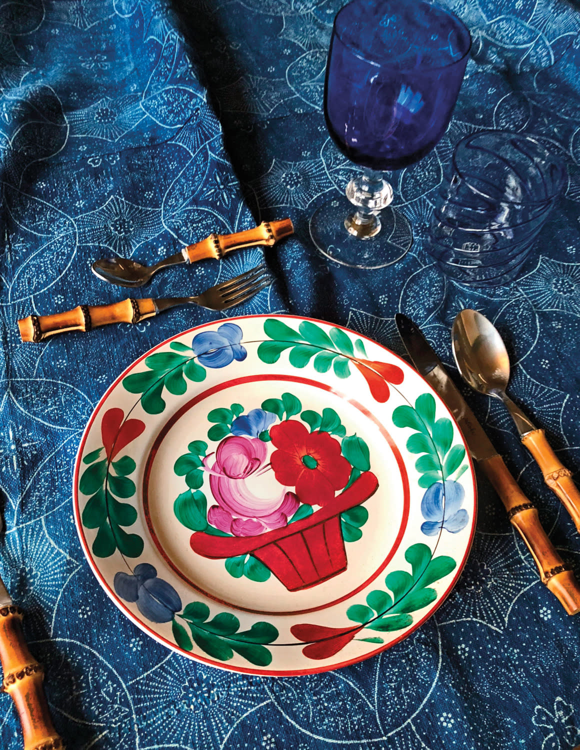 colorful and patterned tabletop with plate, linens and cutlery