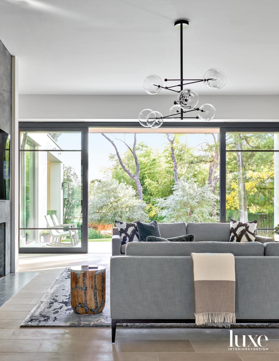 family room with charcoal sofa and globe chandelier