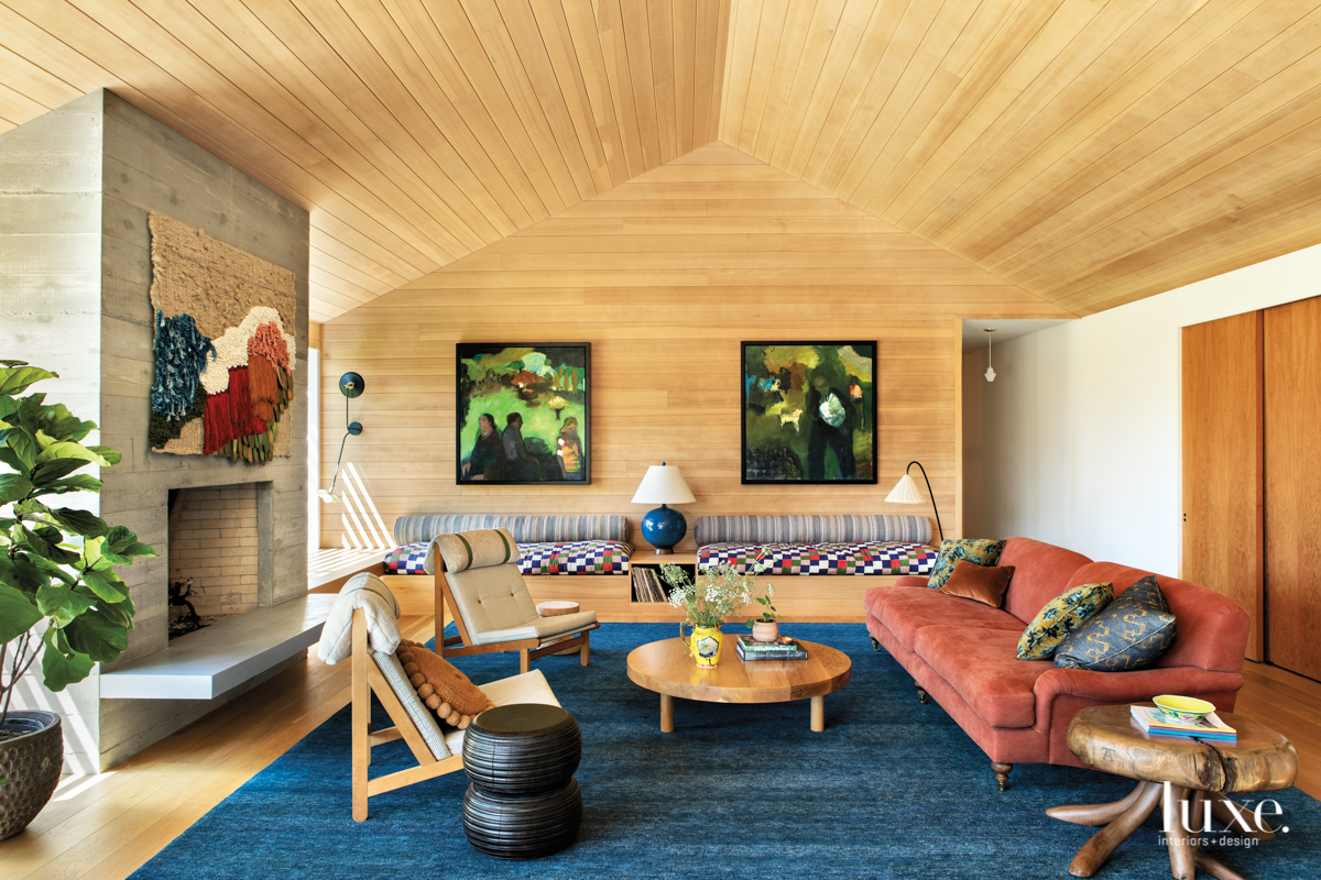 Living room with fiber wall-hanigng, pink couch and quilt covered built ins