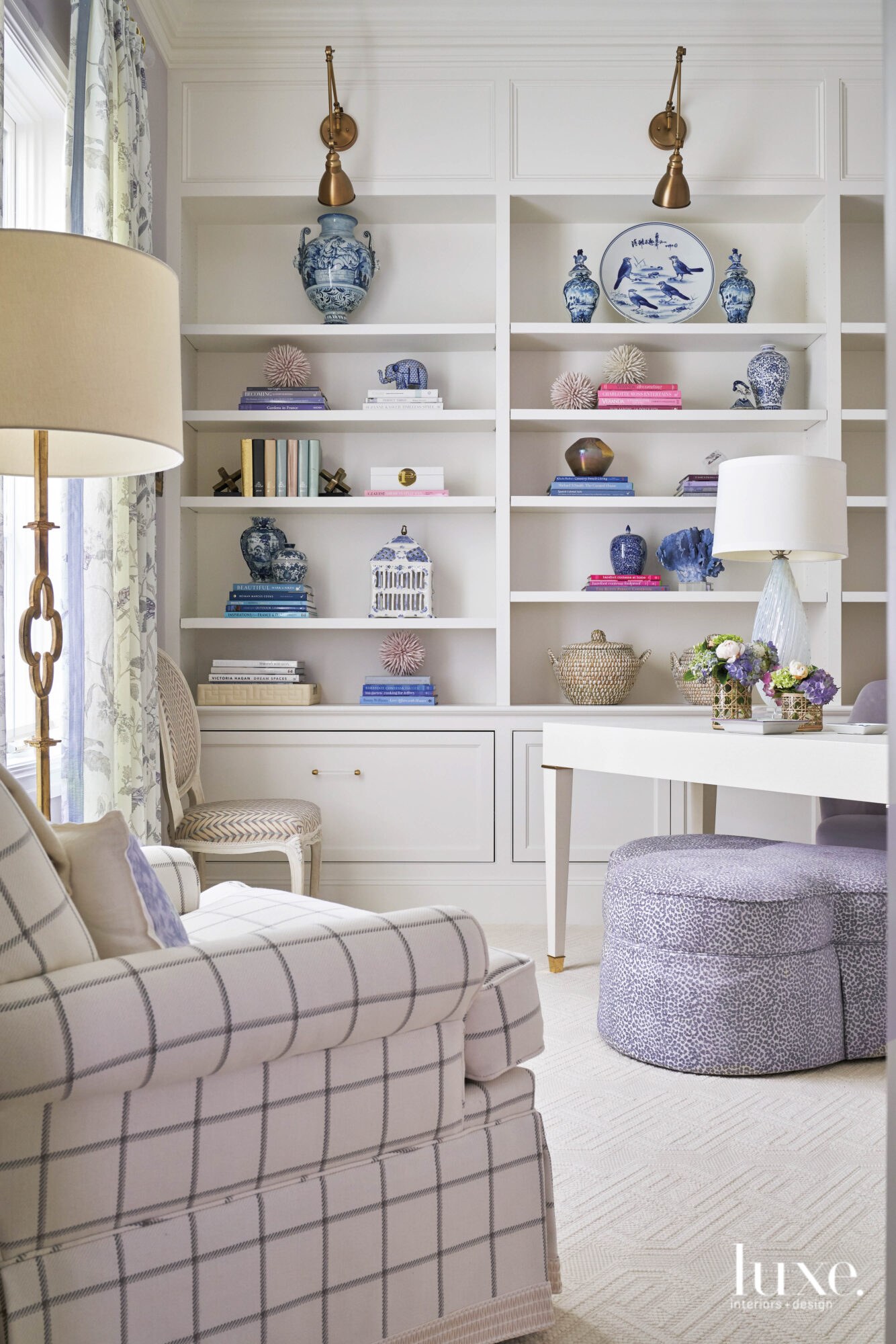 colorful office with white shelving, plaid armchair and many items on display