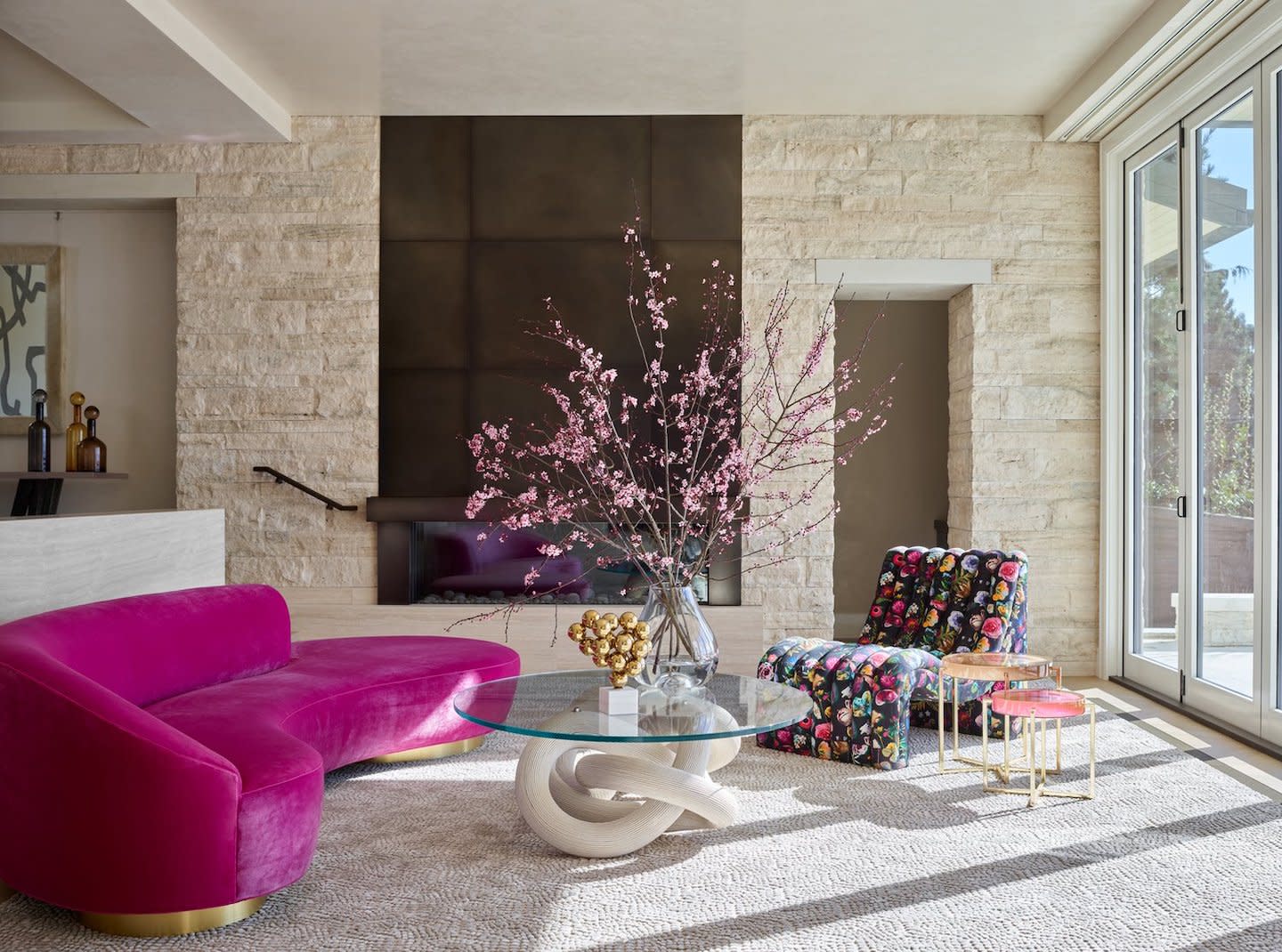 pink couch in front of stone accent wall by julie kleiner