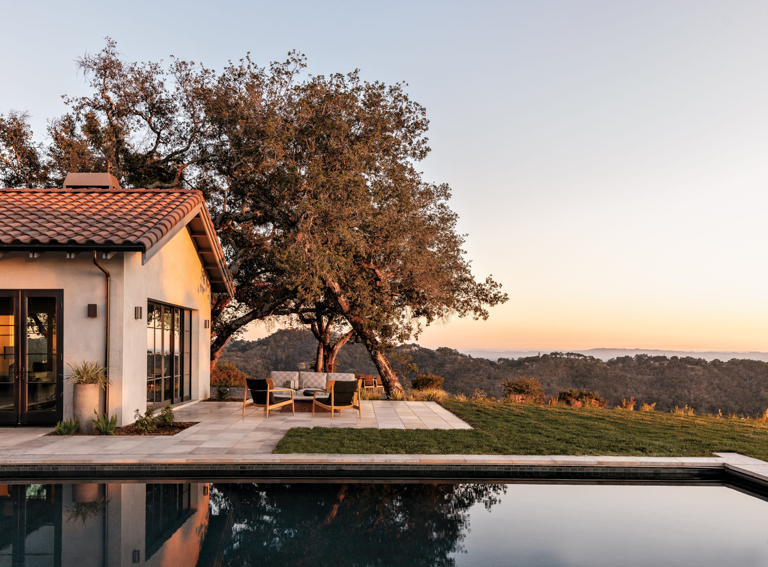 outdoor lounge area overlooking pool and exterior views in home by Caitlin Jones Ghajar