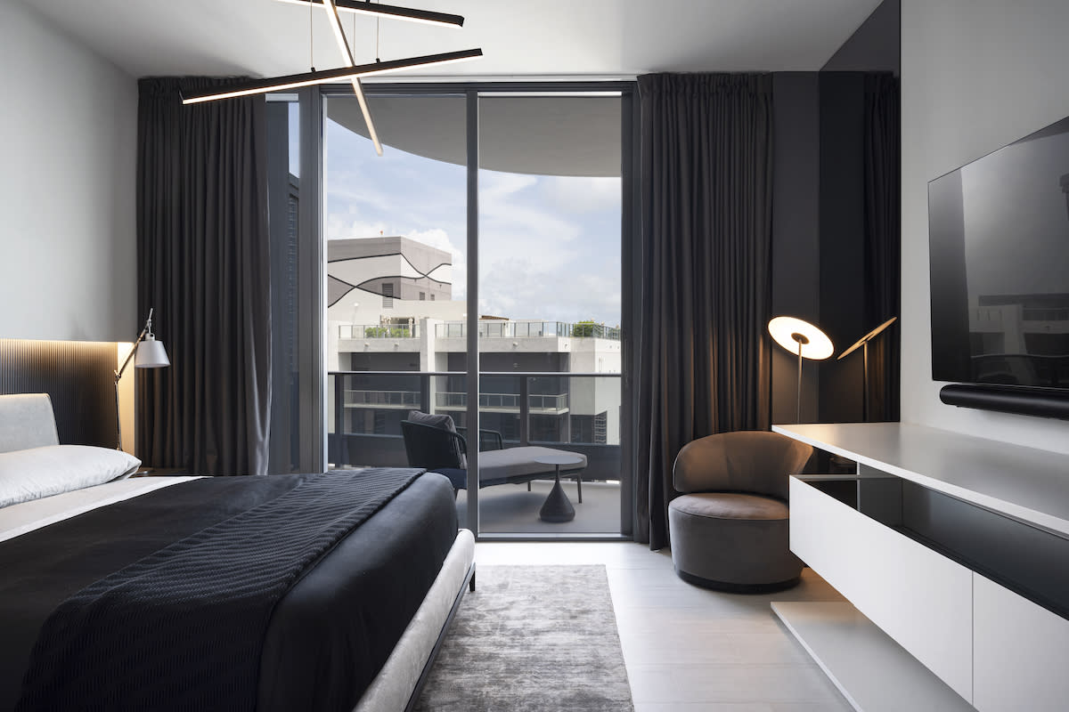 Floor to ceiling black curtains, black bedding, white dresser