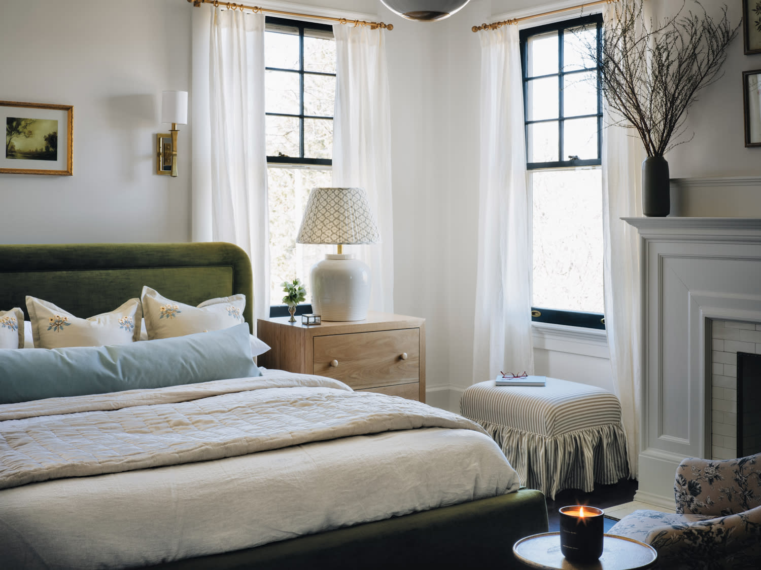 Bedroom with green upholstered bed and open windows