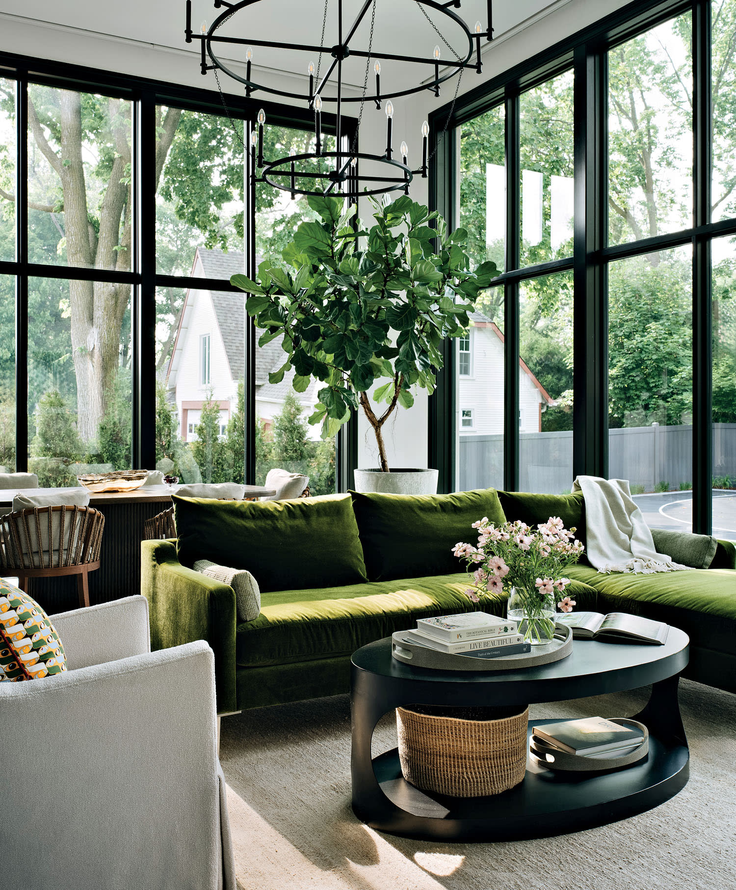 lounge area with a green sectional and floor-to-ceiling windows letting in natural light
