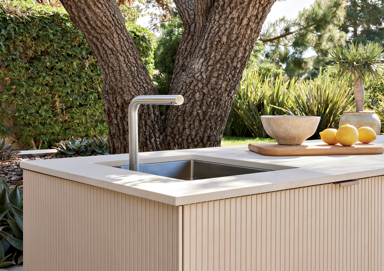 outdoor kitchen system with reeded paneling surrounding it