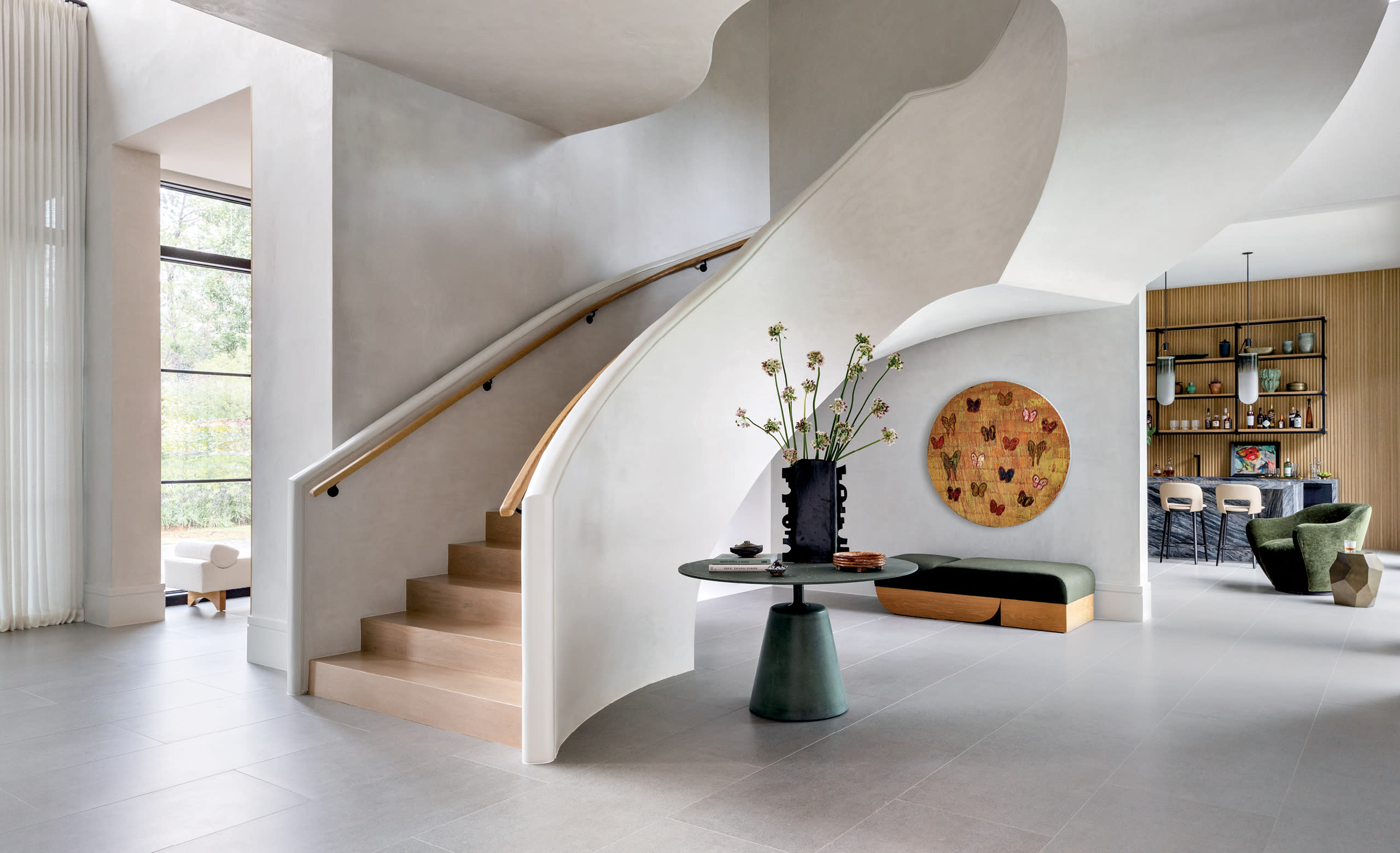 contemporary entryway with a curved plaster stairway with white oak treads