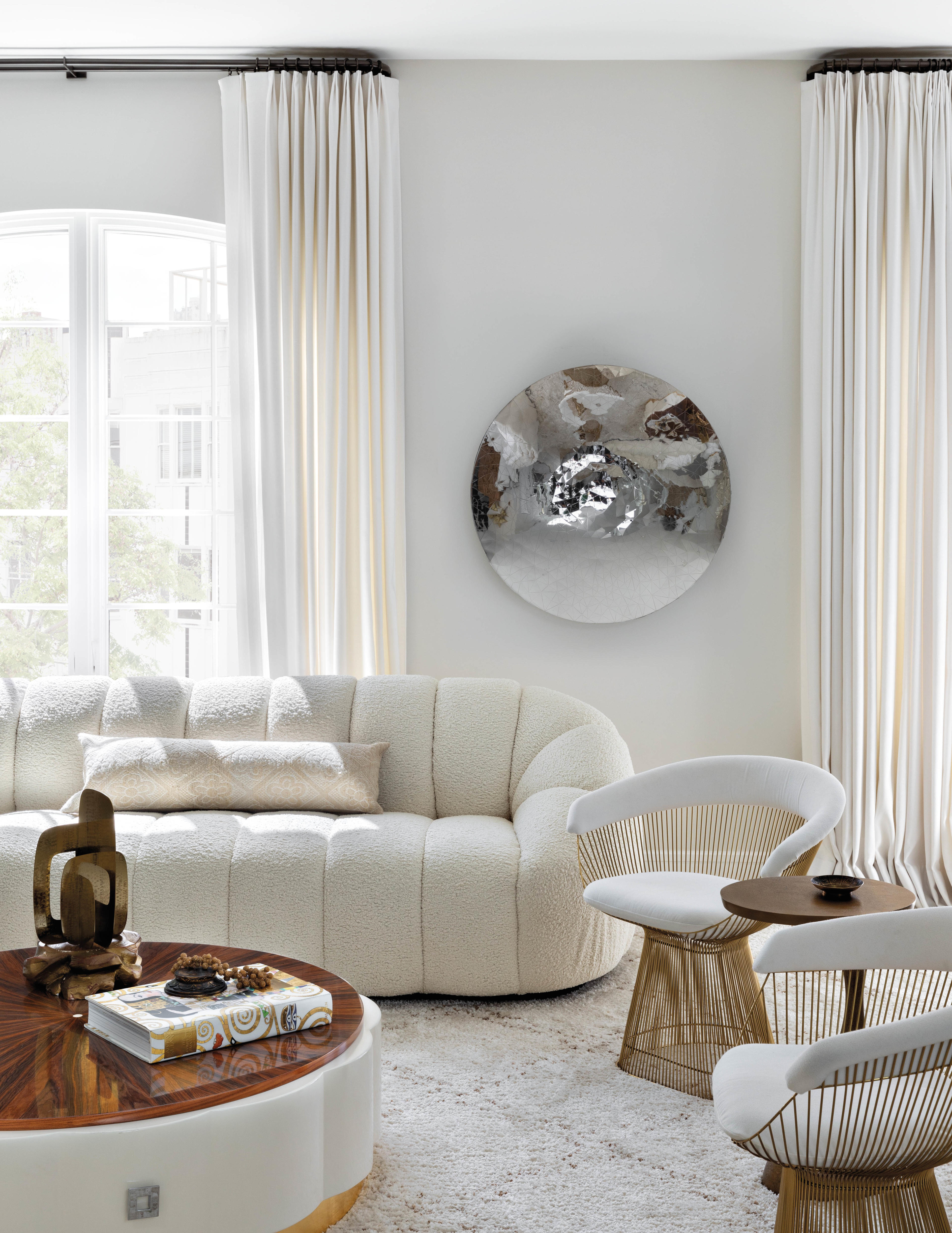 white living space with cloud couch and modern round coffee table 