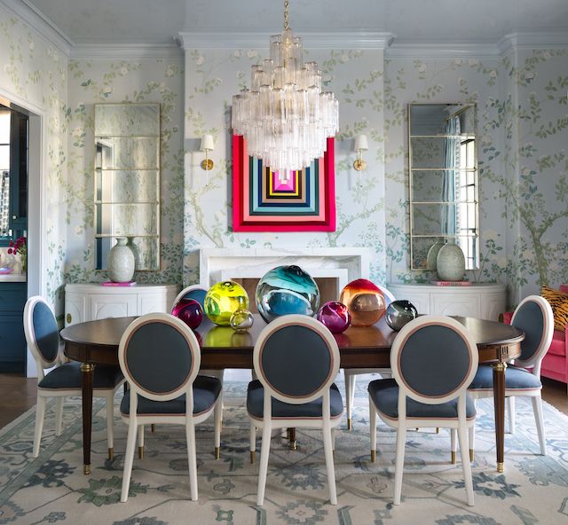 A vibrant dining room with a chandelier, adorned with colorful wallpaper, creating an inviting ambiance.