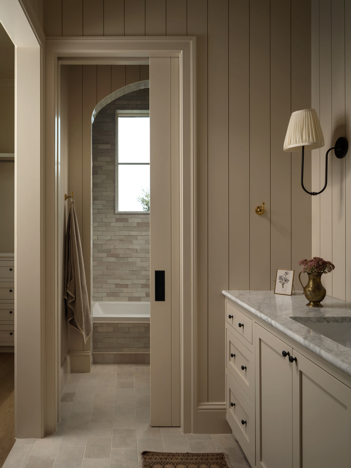 Secondary bathrooms deserve the same care and intention as any space. Limestone floors and zellige tile bring warmth and an organic character, creating a thoughtful retreat meant to be enjoyed everyday. Builder: Cedar and Oak Homes.