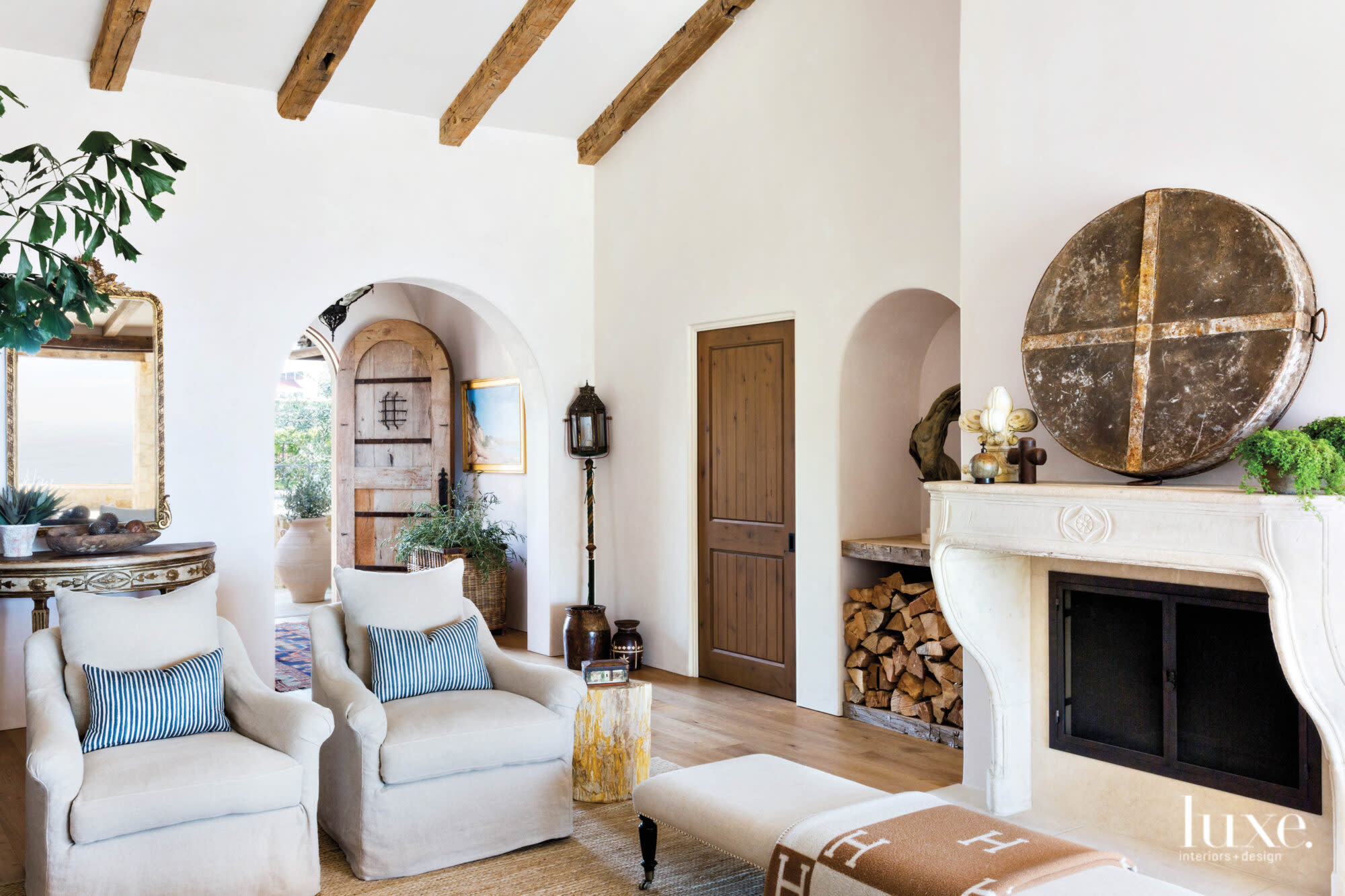 View from living room with fireplace and pair of chairs through to main entry