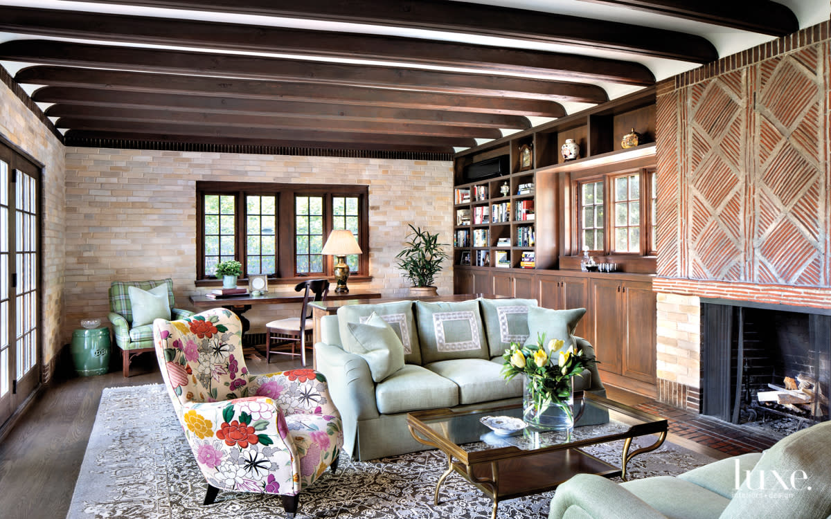 Reading room with dark wood beams, brick fireplace and wood beams.