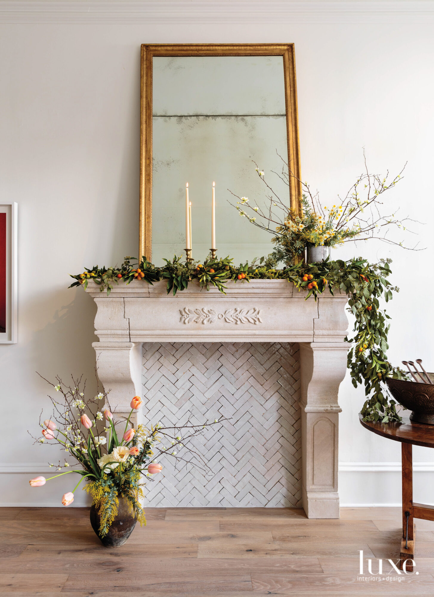 A fireplace mantel is decorated by a garland.