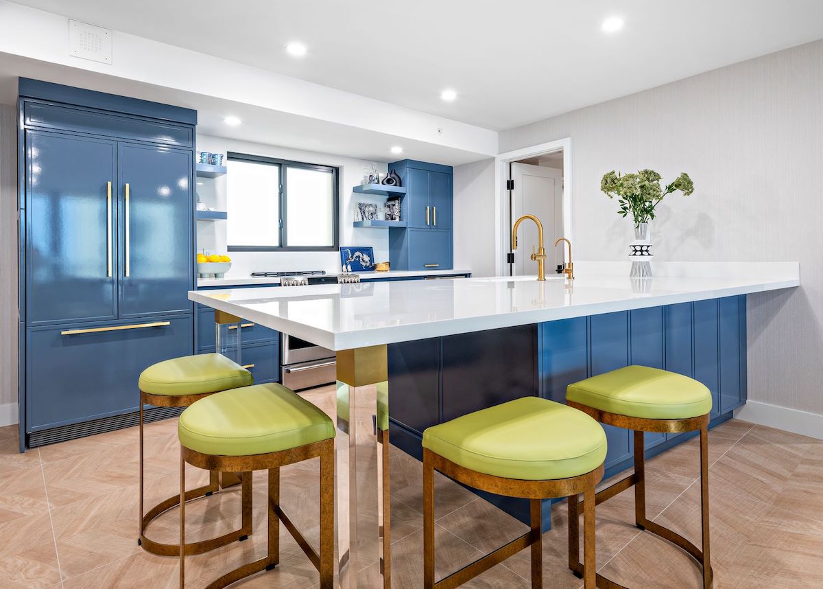 Kitchen with blue island, green stools.