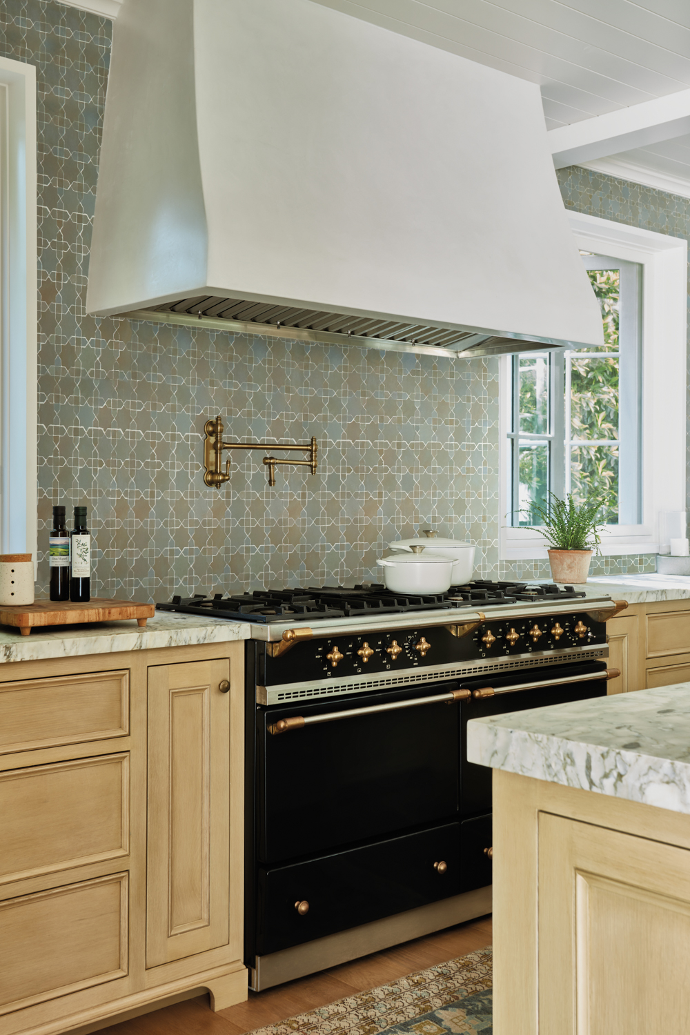 black Lacanche stove with white plaster hood against Moroccan tiles