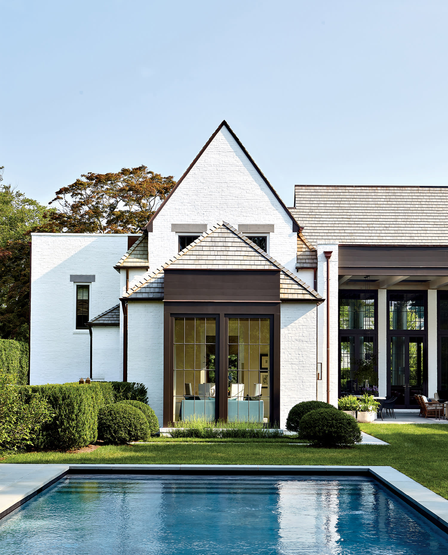 A-frame section of a home's exterior overlooking a pool in the Hamptons