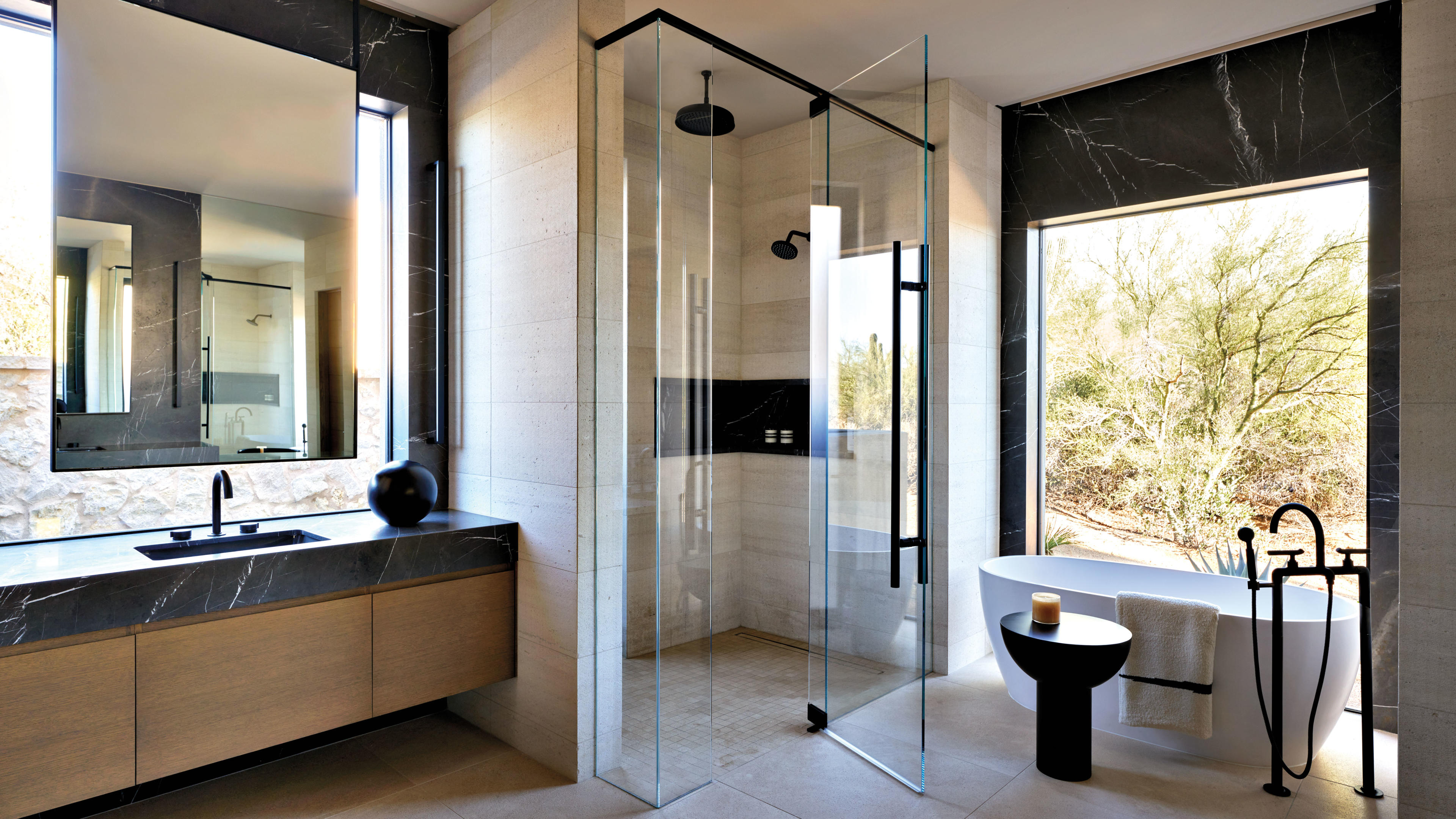 chic bathroom with freestanding tub in front of window with views of the desert