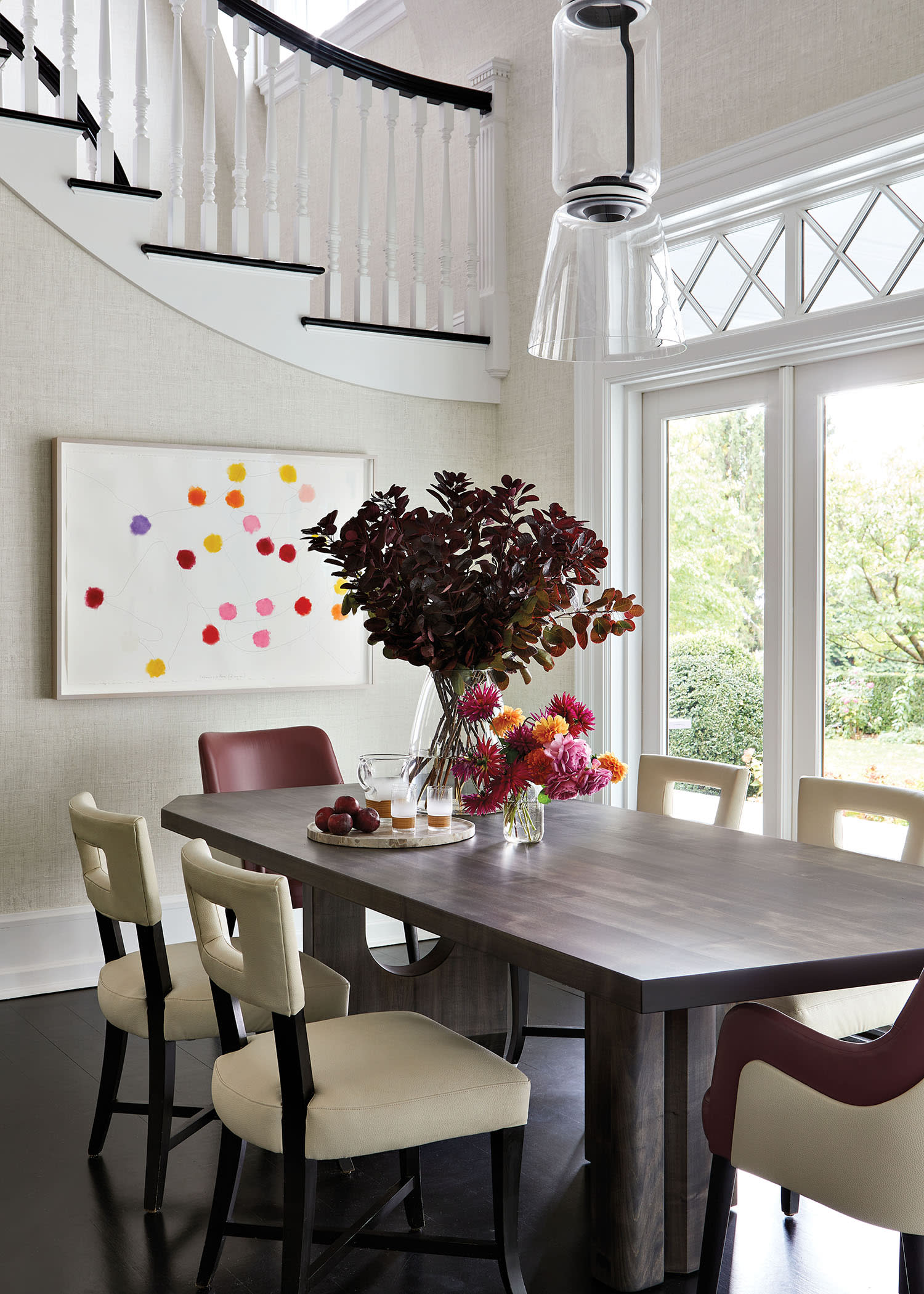 contemporary breakfast area with a dotted artwork on the staircase wall next to the table