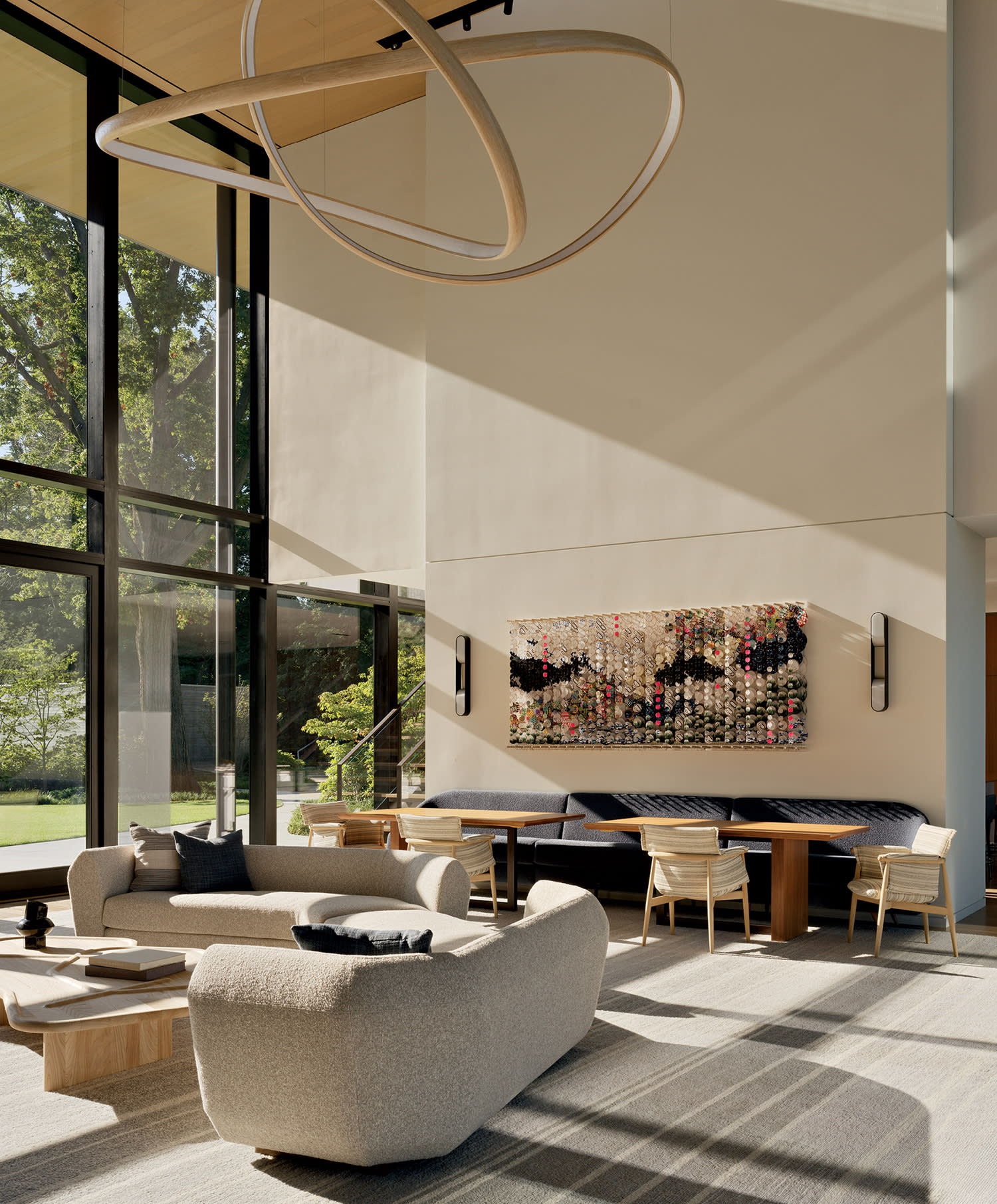 contemporary living room with a curving sectional and a John Procario chandelier