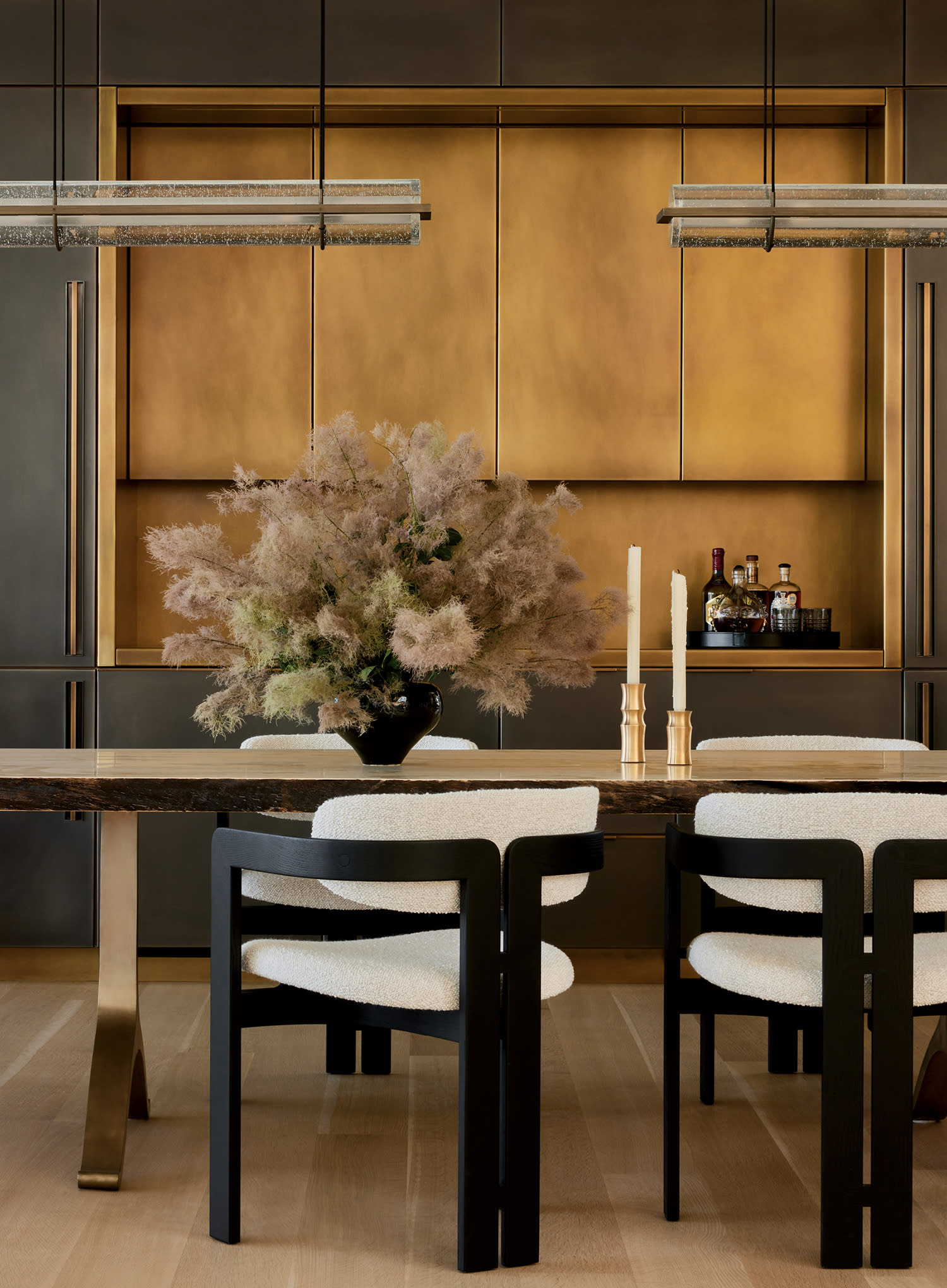 modern dining room flanked by a bronze bar