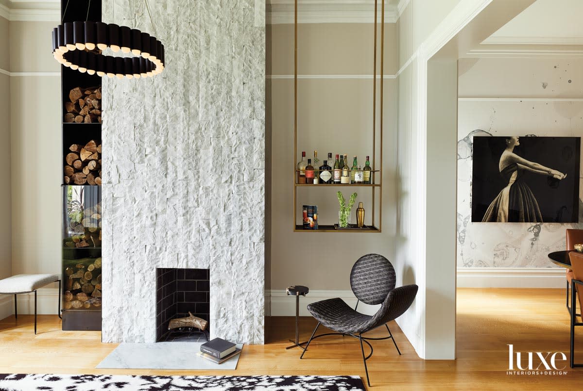 carrara marble fireplace with black accent chair