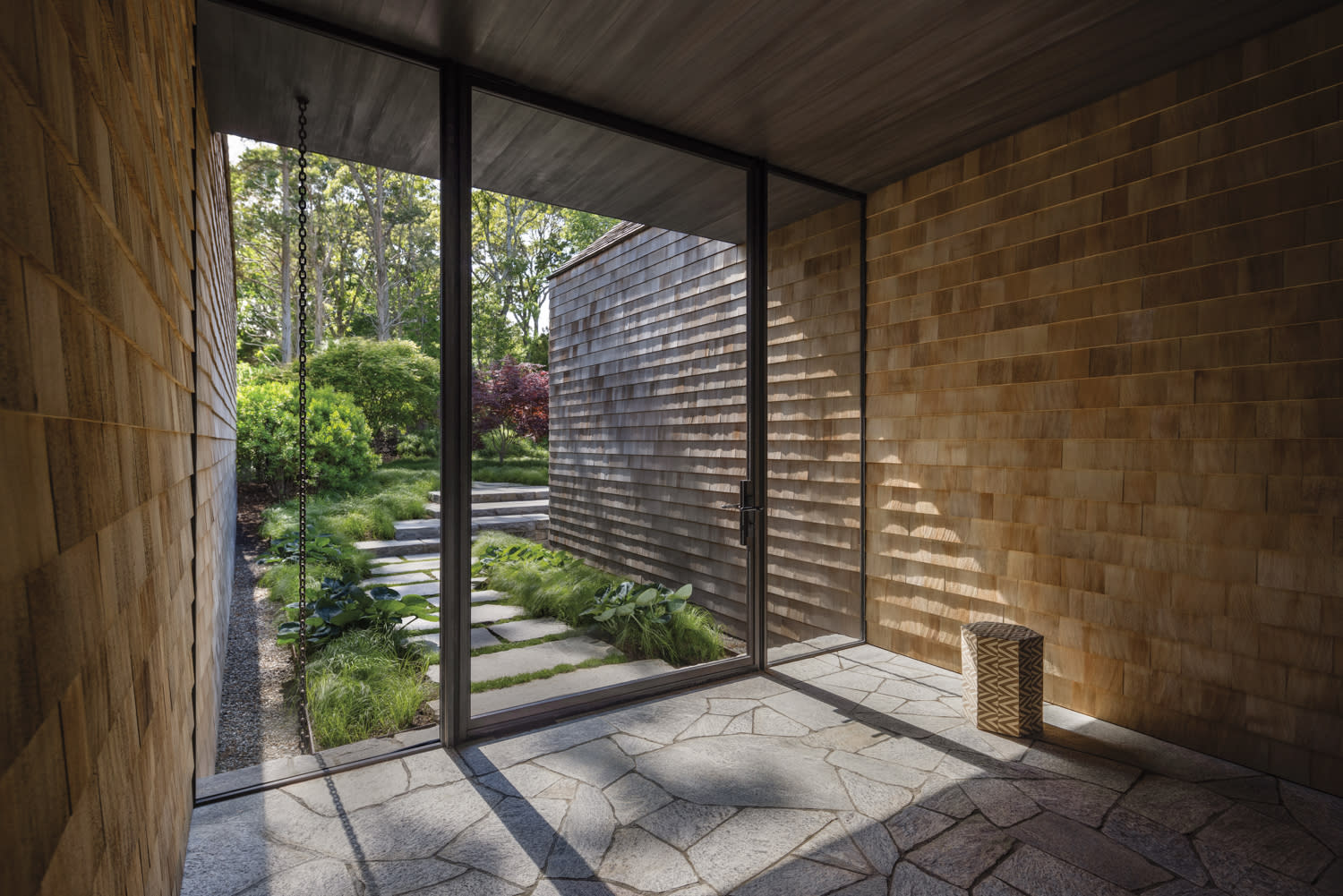 foyer with stone flooring and cedar shingled-walls
